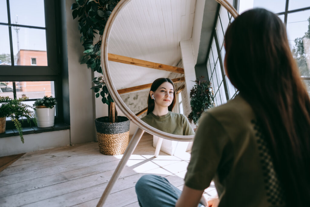 woman reflectively looking into a mirror