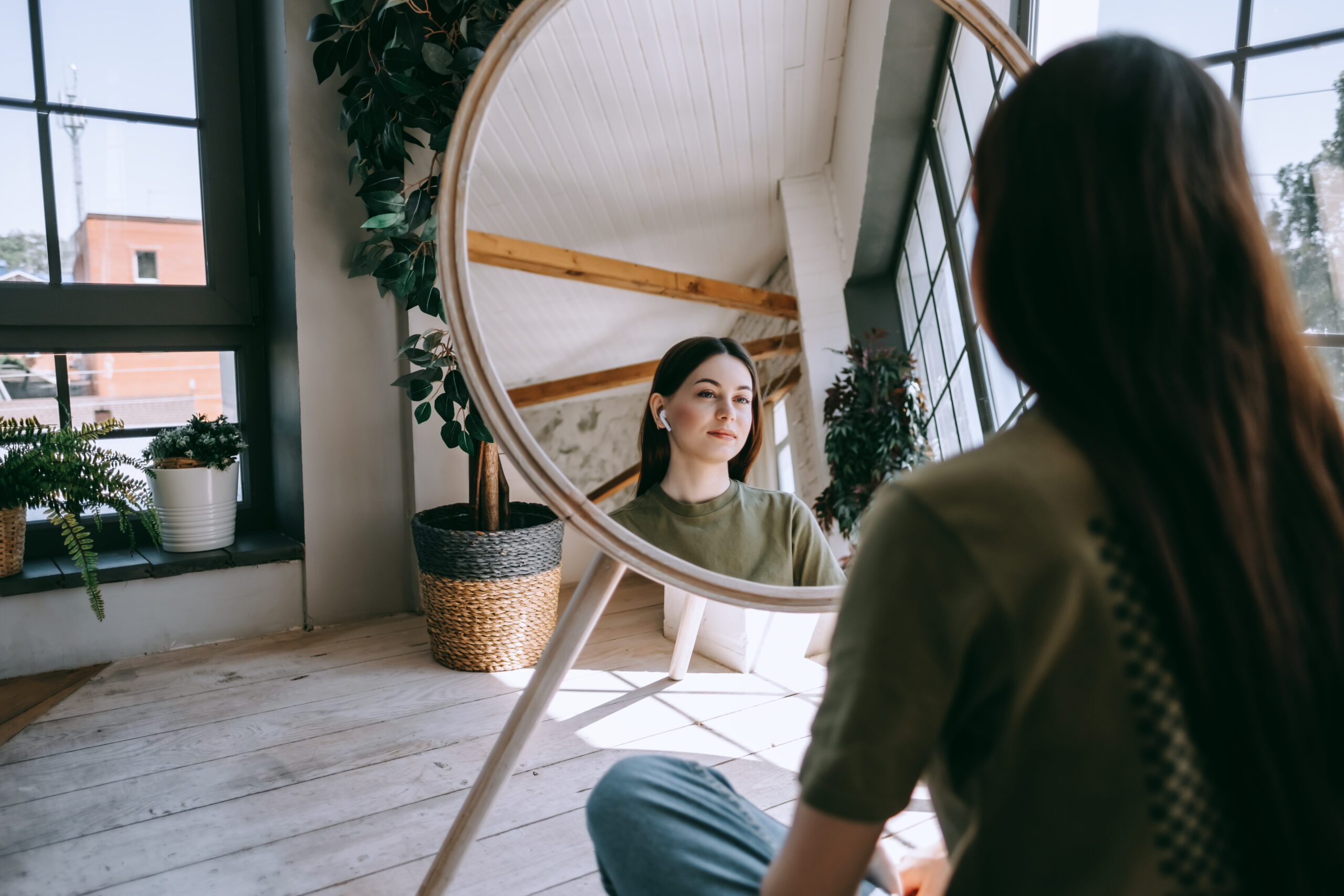 woman reflectively looking into a mirror