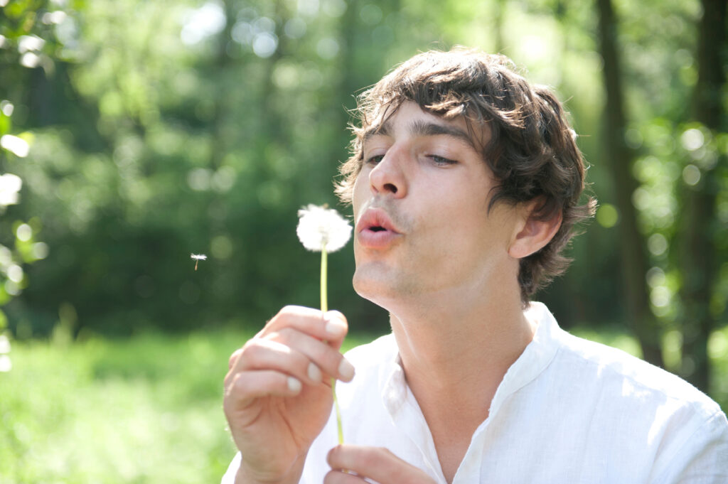 Man blowing a dandelion