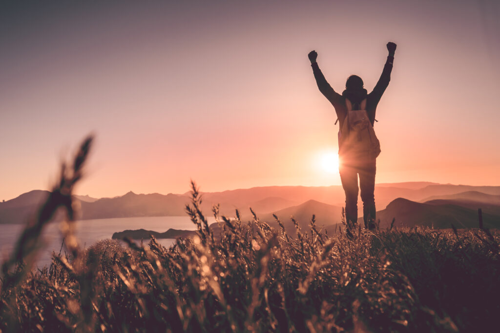 young man with backpack with a sunset in the back