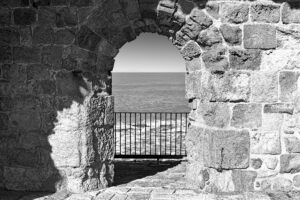 beach, sea, archway made of old brick, greyscale